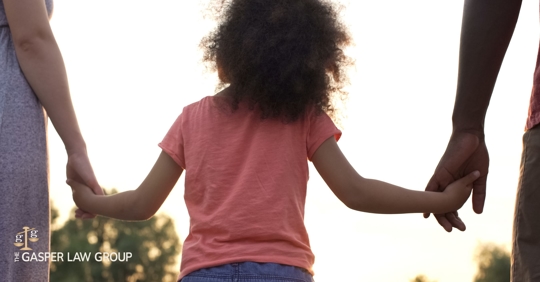 child holding hands with two parents
