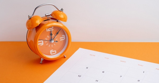 alarm clock and calendar on a table