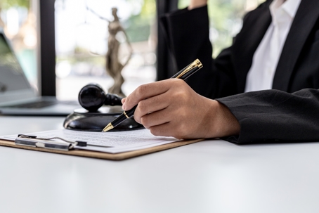 A male lawyer is signing a plea agreement with a client in a fraud case, in which the client has filed a lawsuit against an employee at a company that commits the fraud. Fraud litigation concept.